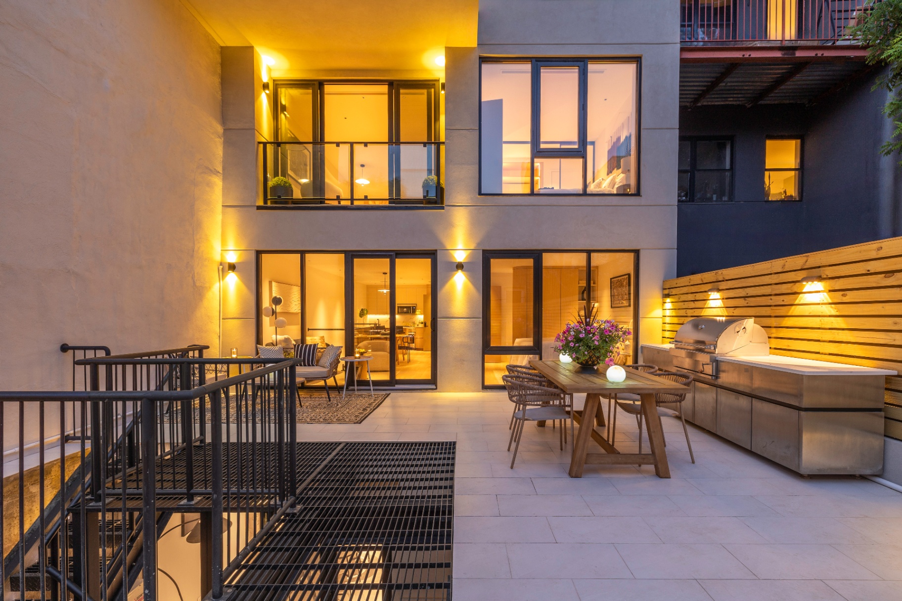 Residence 1B rear patio at night with grill and dining